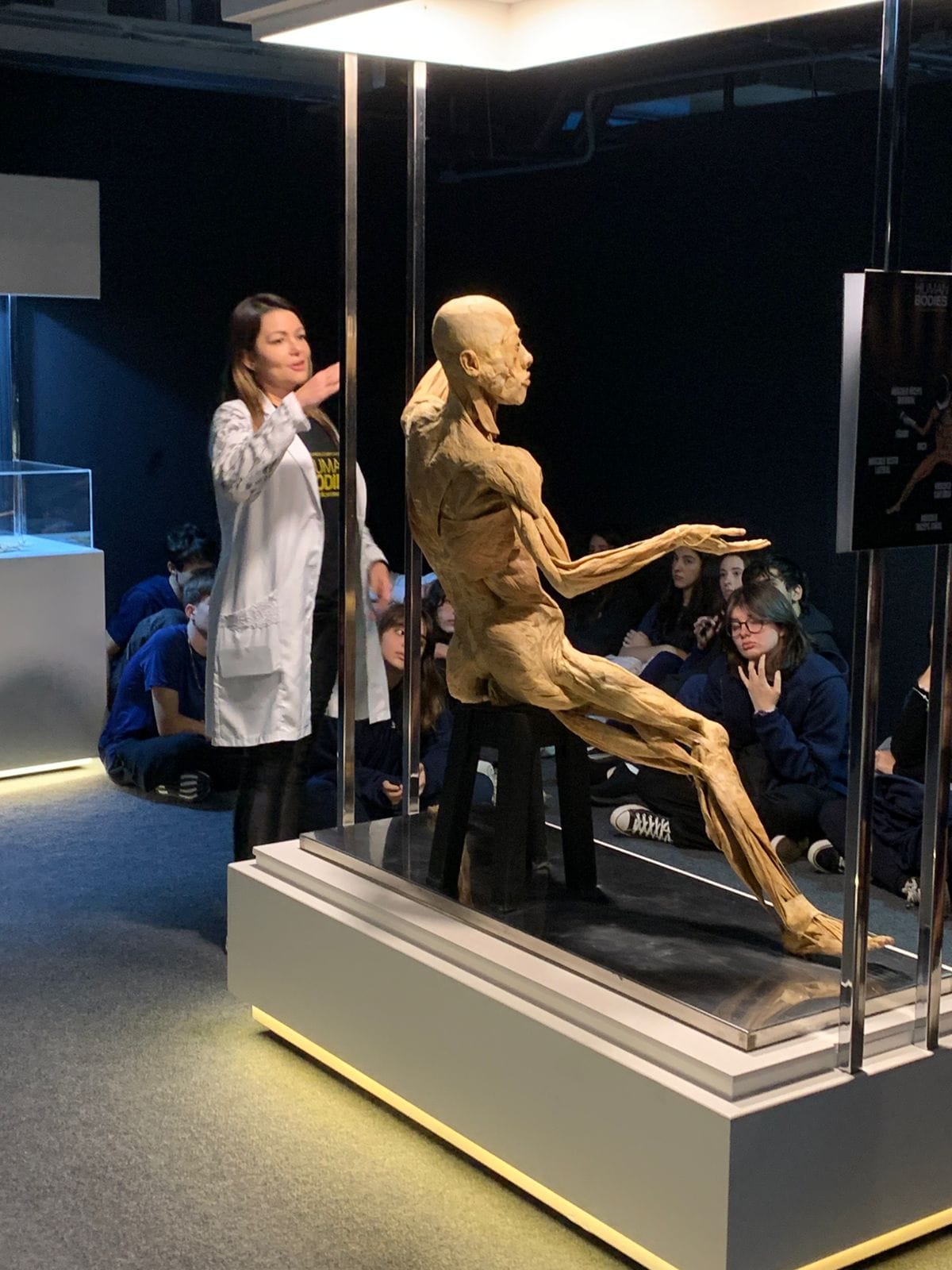 Monitora conduzindo uma turma de alunos em visita guiada à exposição Human Bodies